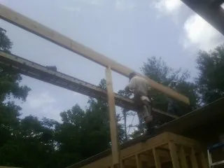 Carpenter setting a ridge beam over a new addition frame — Ice Dam Removal by Roofing Brothers in Wakonda