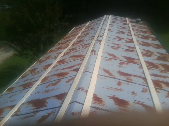 Rusted metal roof panels with new wood purlins before replacement — Storm Damage Roof Repair in Wakonda by Roofing Brothers